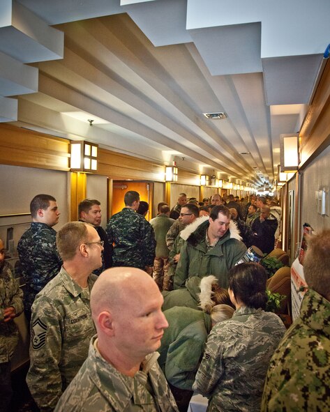 Troops vote for the "Ugliest Sweater" contest winners as they stand in line for the holiday meal served by the 934th Airlift Wing leadership at the Services Club during the December Unit Training Assembly weekend.  The Air Force, Navy, and Marine Corp Reserve units all held their monthly training this weekend at the Minneapolis-St. Paul Air Reserve Station, Minn.  (U.S. Air Force photo by Shannon McKay/Released)