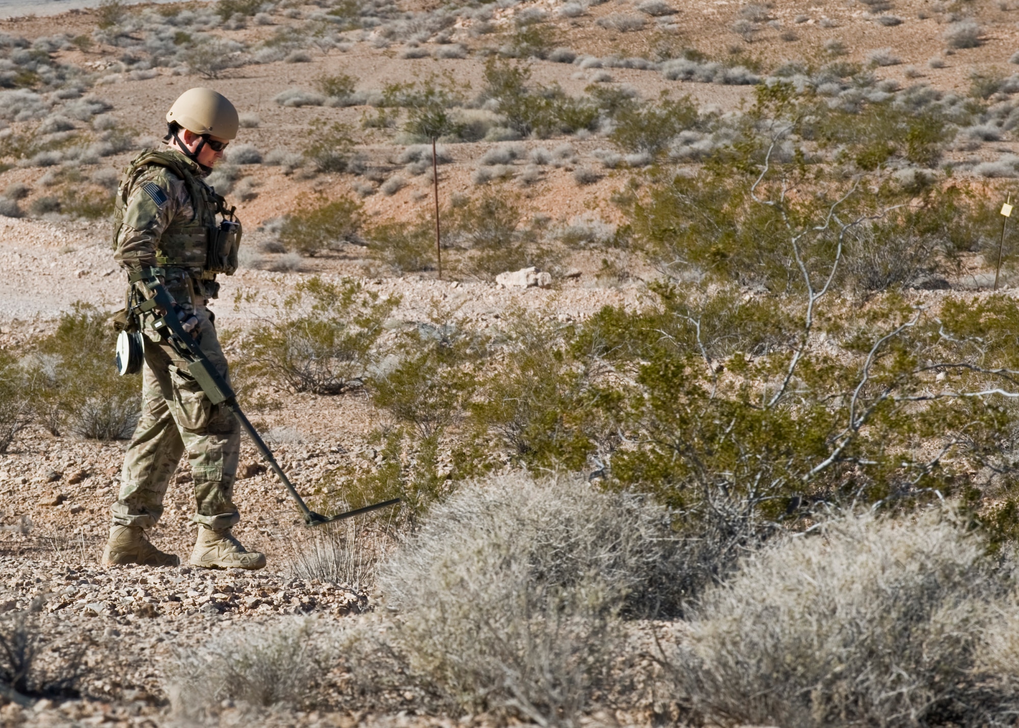 U.S. Air Force Staff Sgt. Daniel Esselstrom, 23rd Civil Engineer Squadron explosive ordnance disposal technician, Moody Air Force Base, Ga., uses a mine detector to check for an improvised explosive device during an IED training course Dec. 12, 2013, in Area 2 at Nellis AFB, Nev.  During the two-week EOD Counter IED-course, students are tested during 56 operations which simulate scenarios at home station and deployed locations. (U.S. Air Force photo by Airman 1st Class Jason Couillard)

