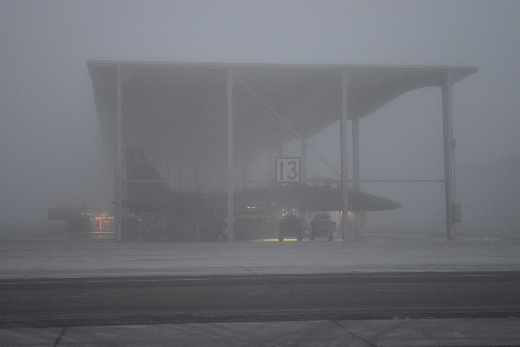An F-15E Strike Eagle sits under cover during the morning fog Dec. 18, 2013, at Mountain Home Air Force Base, Idaho. Regardless of the weather conditions, Airmen work outside around the clock. (U.S. Air Force photo by Senior Airman Benjamin Sutton/Released)