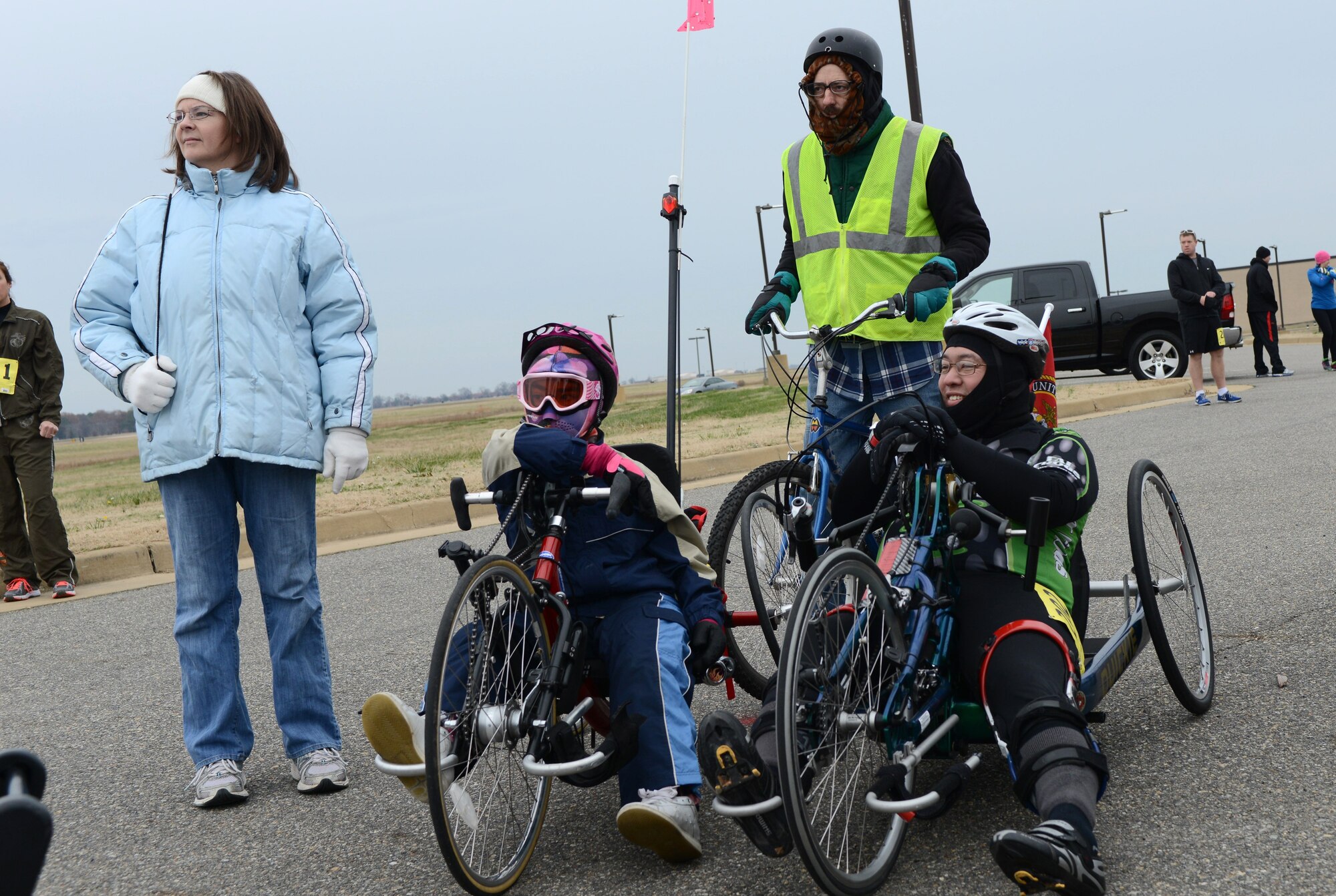 From left to right, 11-year old Rebecca Rollick and Darrin Snyder prepare for the 4th annual “Race ‘Round the Base” at Langley Air Force Base, Va., Dec. 14, 2013. The race allowed handicapped participants to use crank bikes on the course, which went around the outer loop of Langley AFB, through base housing and near the flightline. (U.S. Air Force photo by Senior Airman Connor Estes/Released)