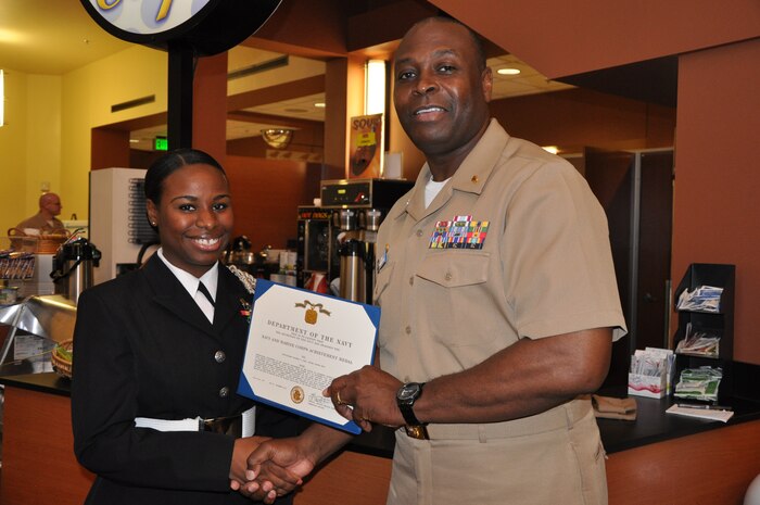 Hospitalman Yolanda King, Naval Health Clinic Charleston optometry technician receives the Navy and Marine Corps Achievement Medal from Capt. Marvin Jones, NHCC commanding officer during a morning colors ceremony Dec. 6, 2013, at NHCC. King was recently named NHCC’s 2013 Bluejacket of the Year. (U.S. Navy photo/Chris Patterson)