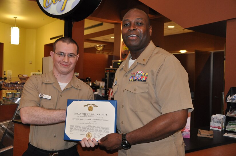 Petty Officer 2nd Class Cody Davis, a hospital corpsman and Naval Health Clinic Charleston Laboratory Department leading petty officer, receives the Navy and Marine Corps Achievement Medal from Capt. Marvin Jones, NHCC commanding officer, during a morning colors ceremony Dec. 6, 2013, at NHCC. Davis was recently named NHCC’s 2013 Junior Sailor of the Year. (U.S. Navy photo/Kris Patterson)