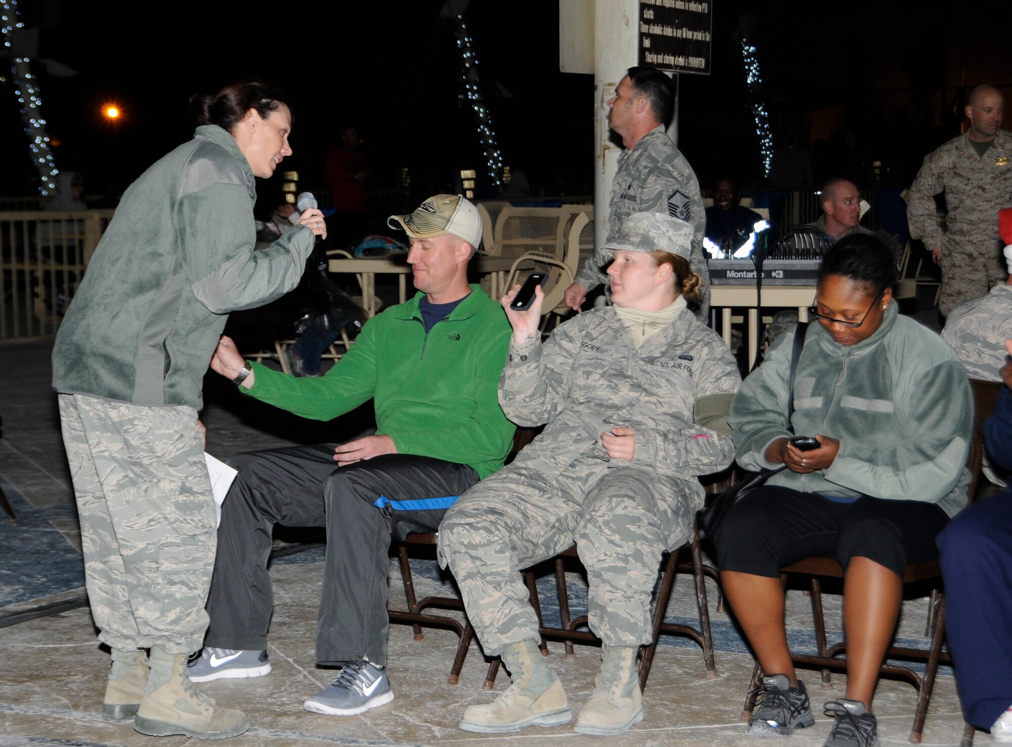Deployed service members participate in a musical chair scavenger hunt during the Christmas tree lighting celebration at the 379th Air Expeditionary Wing in Southwest Asia, Dec. 16, 2013. Deployed service members were invited to participate in the events hosted by the 379th Expeditionary Force Support Squadron.  The 379th EFSS organized music, games and photos with Santa Claus to boost morale during the holiday season. (U.S. Air Force photo/Senior Airman Hannah Landeros)