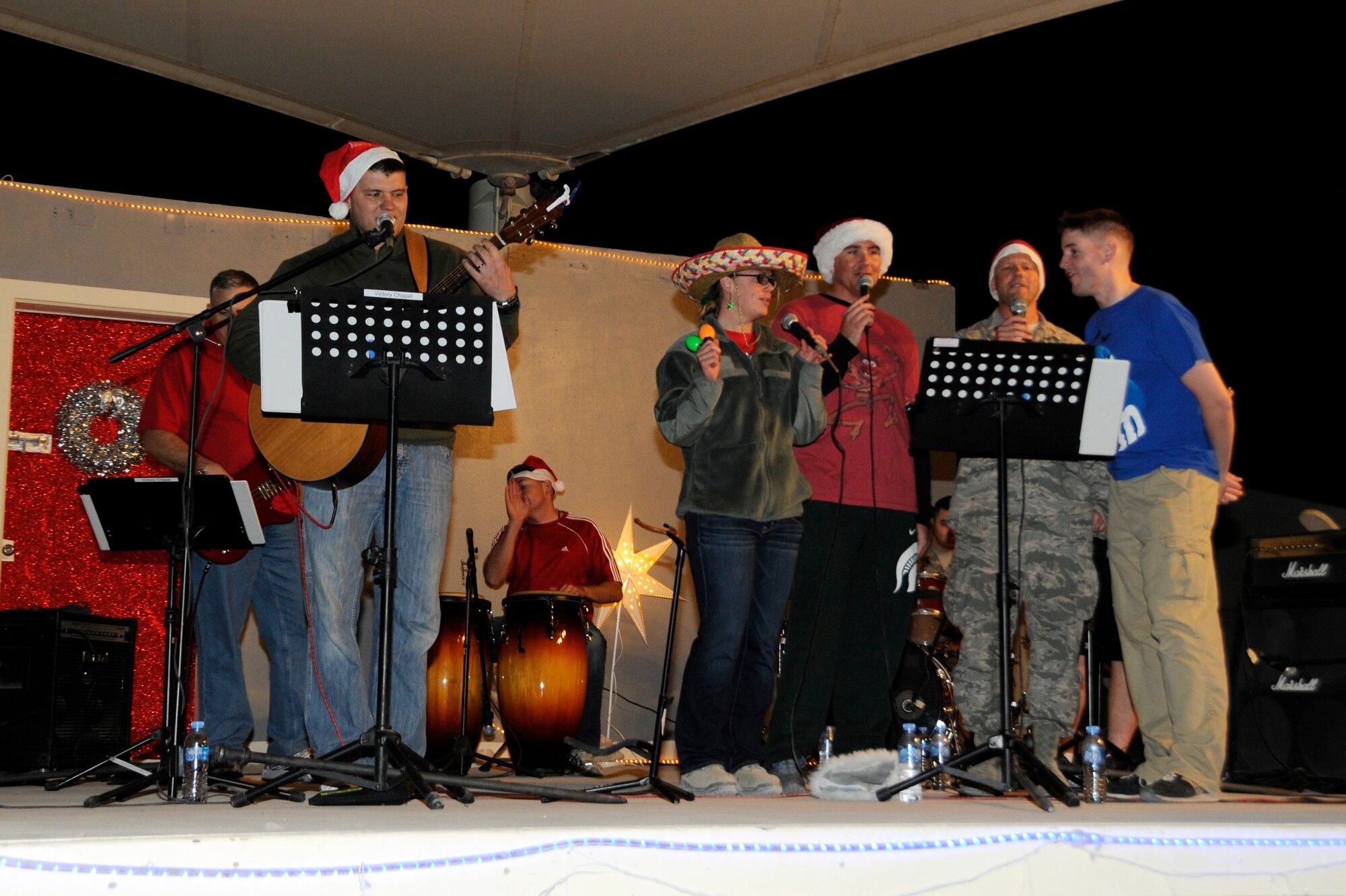 Airmen from the 379th Air Expeditionary Wing Victory Chapel sing Christmas carols during the Christmas tree lighting celebration in Southwest Asia, Dec. 16, 2013. The Victory Chapel band is made up of volunteer Airmen currently deployed to the 379th AEW. (U.S. Air Force photo/Senior Airman Hannah Landeros)