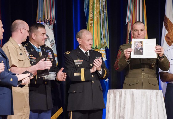 18th Chairman of the Joint Chiefs of Staff Gen. Martin E. Dempsey joins Senior Enlisted Advisor to the Chairman Sgt. Maj. Bryan B. Battaglia in the roll out of the first of its kind Noncommissioned Officer and Petty Officer Book in the Pentagon Auditorium, Dec. 17, 2013. DOD photo by U.S. Army Staff Sgt. Sean K. Harp. 
