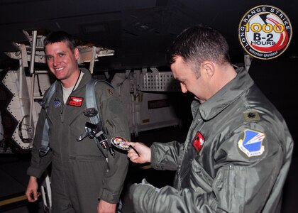 Lt. Col. Jared Kennish, 110th Bomb Squadron Commander, presents Maj. Tim Rezac with his 1000 B-2 flying hour patch, Dec 13, 2013. Only 36 pilots have ever reached 1000 B-2 hours, and just thirteen still actively fly the B-2 Stealth Bomber.