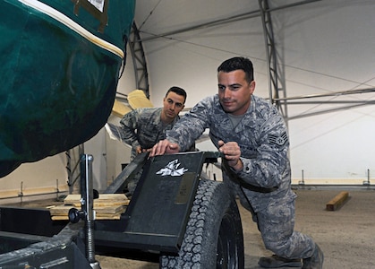 Twin brothers Air Force Staff Sgt. William Medeiros, right, and Air Force Senior Airman Barrington prepare a spare engine for a C-130J in Southeast Asia, Dec. 11, 2013. The Rhode Island Air National Guardsmen serve together with the 386th Expeditionary Aircraft Maintenance Squadron.