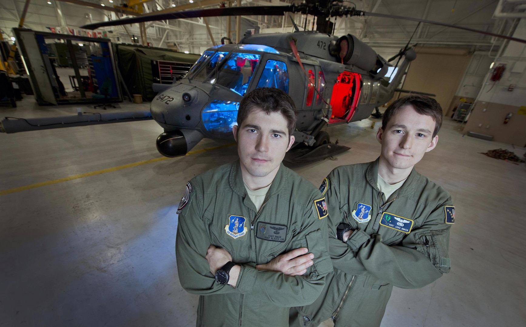 Air Force Staff Sgt. Cody Inman, a pararescue jumper assigned to the 210th Rescue Squadron, Alaska Air National Guard, left and his brother Air Force Staff Sgt. Jacob Inman, a special mission aviator assigned to the 212th Rescue Squadron, Alaska Air National Guard, stand in front of a HH-60 Pave Hawk helicopter on Joint Base Elmendorf-Richardson, Alaska, Nov. 20, 2013.