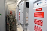 Col. Larry Herke, deputy facilities officer, shows the 40kW solar photovoltaic systems contol center at the new Field Maintenance Shop.