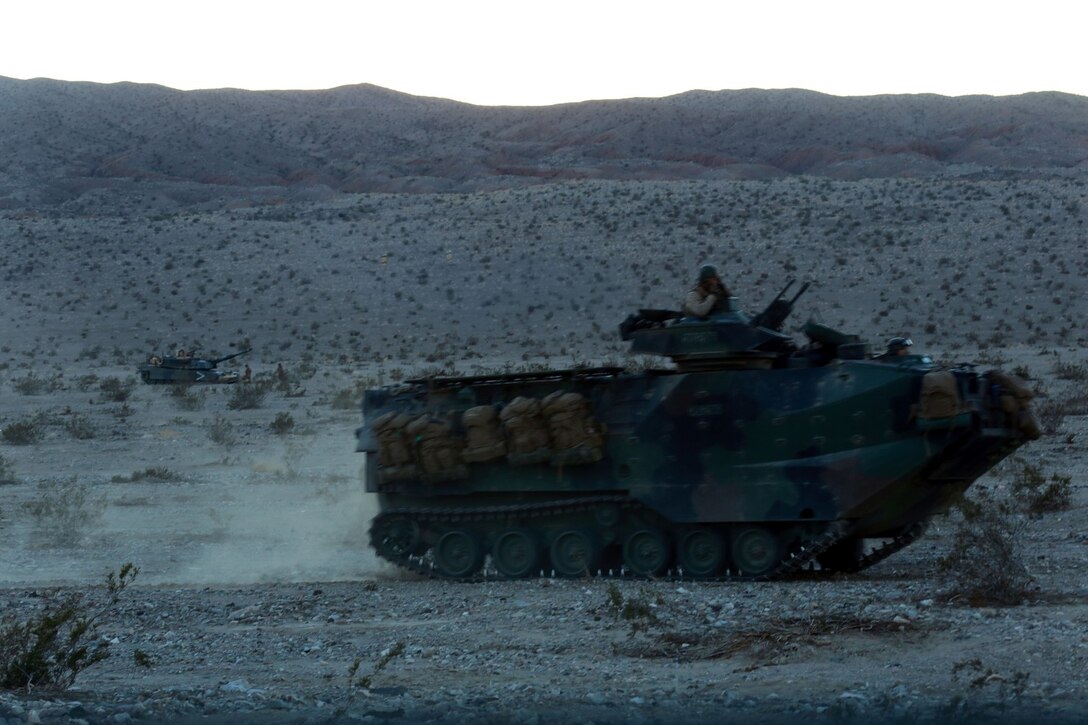 Marines with Alpha Company, 1st Battalion, 5th Marine Regiment, provide suppressing fire during a mechanized raid in support of Exercise Steel Knight 2014 at Marine Corps Air Ground Combat Center Twentynine Palms, Calif., Dec. 13, 2013. The battalion played a vital role in the ground combat element during the assault which prepared them for their upcoming deployment to Australia. Steel Knight is an annual exercise that includes elements from the entire I Marine Expeditionary Force (MEF). The exercise focuses on conventional operations and provides realistic training that prepares Marines for overseas operations. (U.S. Marine Corps photo by Cpl. James Gulliver/Released)