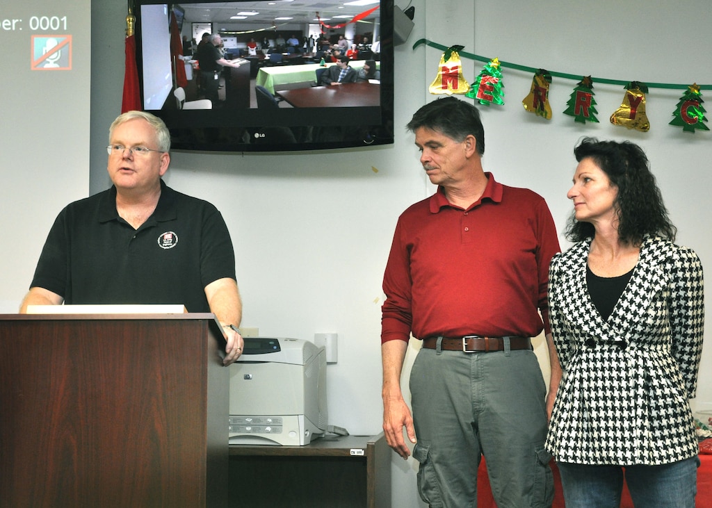 Daryll Fust, the U.S. Army Corps of Engineers Los Angeles District’s assistant chief of staff, presents Theresa Koontz, wife of District Security Manager Jeff Koontz, the Commander’s Award for Public Service at the Arizona-Nevada Area Office during the Dec. 18 Holiday Luncheon as John Keever, the District Construction Division chief, stands with her. Koontz received the award for her efforts in assisting the family of Col. Pete Jordan, who served as the executive officer for the Arizona-Nevada Area Office, after he passed away in a Sept. 7 automobile accident. 