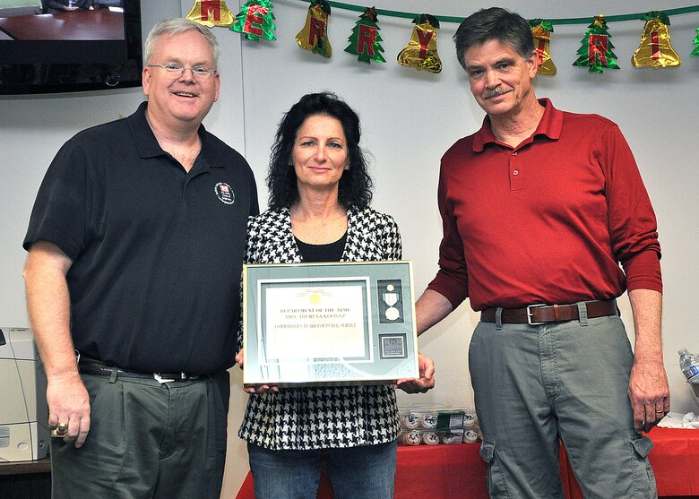 Daryll Fust (left), the U.S. Army Corps of Engineers Los Angeles District assistant chief of staff, and John Keever (right), the District Construction Division chief, present Theresa Koontz, wife of District Security Manager Jeff Koontz, the Commander’s Award for Public Service at the Arizona-Nevada Area Office during the Dec. 18 Holiday Luncheon. Koontz received the award for her efforts in assisting the family of Col. Pete Jordan, who served as the executive officer for the Arizona-Nevada Area Office, after he passed away in a Sept. 7 automobile accident. 