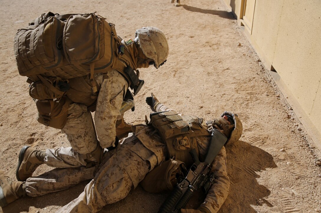 Corporal Phillip Jacoby, team leader, Bravo Company, 1st Battalion, 7th Marine Regiment, and a native of Kalamazoo, Mich., treats a simulated casualty during a counterinsurgency exercise on Range 220 at Marine Corps Air Ground Combat Center Twentynine Palms, Calif., Dec. 9, 2013. The $140 million urban warfare training facility consists of more than 1,000 buildings and is divided into four sectors. The buildings replicate what can be found in an urban town to include gas stations, factories, one story complexes, marketplaces and multiple story buildings. The battalion is slated to continue a vigorous training schedule before deploying to Afghanistan this spring.