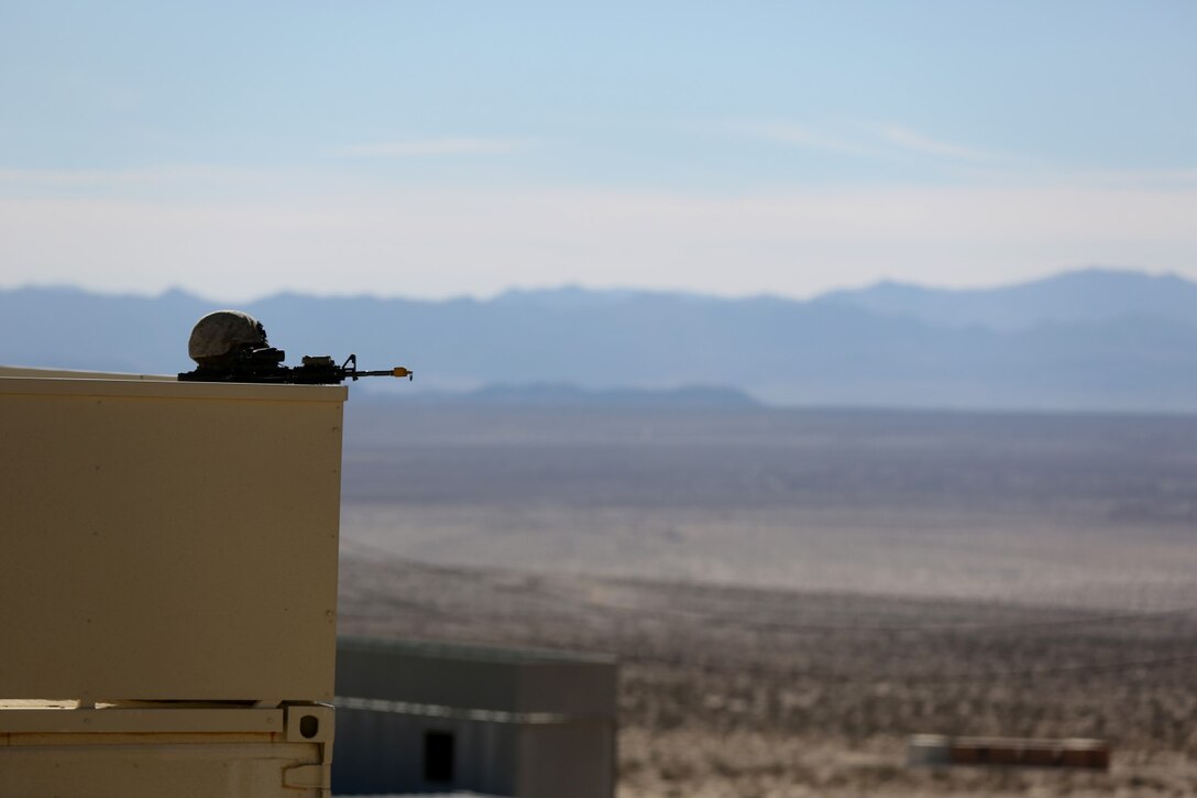 A Marine with Bravo Company, 1st Battalion, 7th Marine Regiment, keeps a low profile while providing security during a counterinsurgency exercise on Range 220 at Marine Corps Air Ground Combat Center Twentynine Palms, Calif., Dec. 9, 2013. The $140 million urban warfare training facility consists of more than 1,000 buildings and is divided into four sectors. The buildings replicate what can be found in an urban town to include gas stations, factories, one story complexes, marketplaces and multiple story buildings.  The battalion is slated to continue a vigorous training schedule before deploying to Afghanistan this spring.