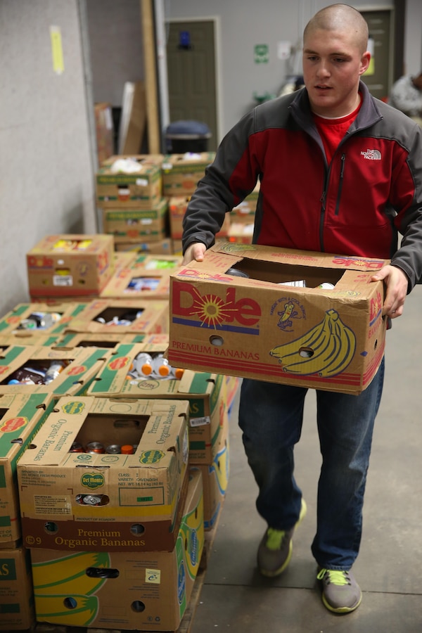 A Marine with 3rd Battalion, 6th Marine Regiment carried a completed box of food during a community relations project with the Food Bank of Central and Eastern North Carolina, in Greenville, N.C., December 17, 2013. “It was turned into a competition of who can break the boxes down and get the boxes sorted the fastest,” said Navy Lt. Reginald E. Jones, the 3rd Battalion, 6th Marine Regiment chaplain, and native of DeSoto, Texas. “We were packing so fast that they wanted us to go to lunch so they can catch up. We probably did a week’s worth of work in only a few hours.”