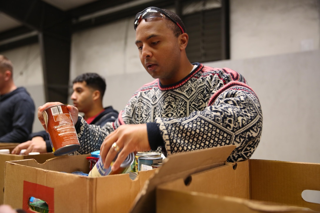 Navy Lt. Reginald E. Jones, the 3rd Battalion, 6th Marine Regiment chaplain, and native of DeSoto, Texas, packs canned goods into a box during a community relations project with the Food Bank of Central and Eastern North Carolina, in Greenville, N.C., December 17, 2013. “It was turned into a competition of who can break the boxes down and get the boxes sorted the fastest,” said Jones. “We were packing so fast that they wanted us to go to lunch so they can catch up. We probably did a week’s worth of work in only a few hours.”