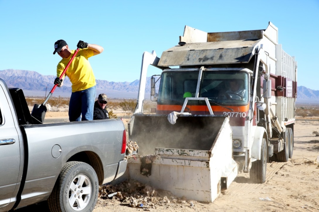 Sgt. Jason Syvrud, rifleman, 3rd Battalion, 4th Marine Regiment, transfers garbage from his vehicle to a dump truck during a community clean-up effort in Wonder Valley, Calif., Dec. 14. More than 40 community volunteers teamed up with Marines from the Combat Center to clean-up debris left from illegal dumping throughout the desert.