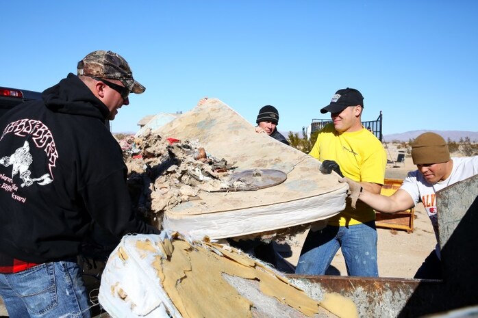 Marines with 3rd Battalion, 4th Marine Regiment, lift a mattress found in the desert into a dump truck during a community clean-up effort in Wonder Valley, Calif., Dec. 14. During a meeting, residents of Wonder Valley recognized the issue of illegal dumping throughout the area and were granted money from the county for garbage bins and necessary equipment to help clean-up the areas.