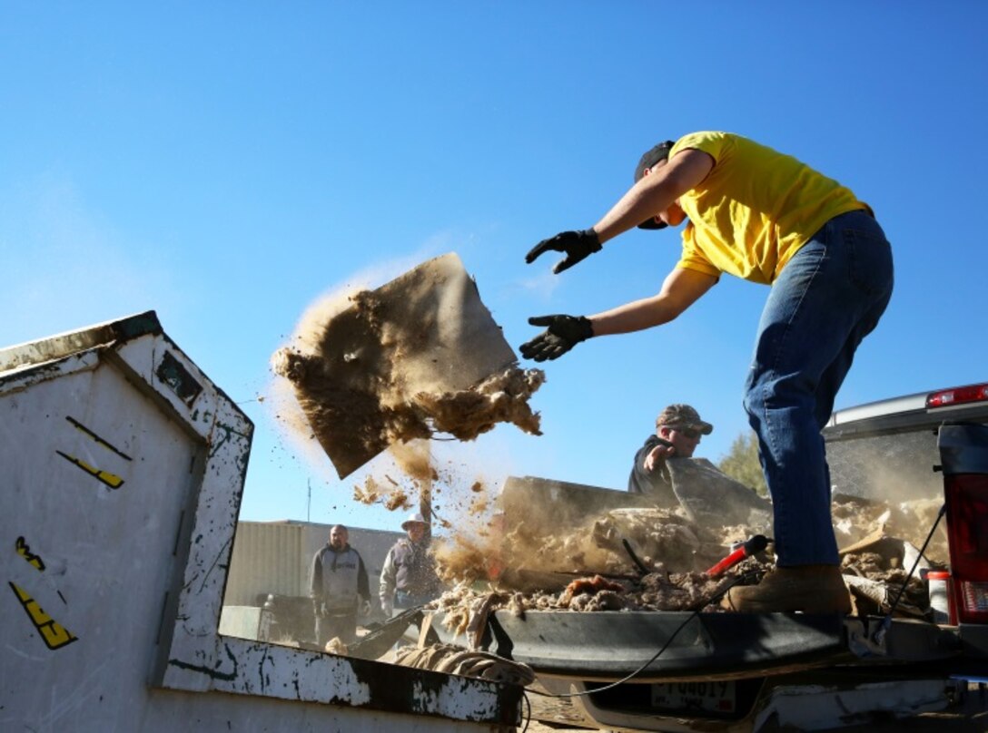 Sgt. Jason Syvrud, rifleman, 3rd Battalion, 4th Marine Regiment, transfers garbage from his vehicle to a dump truck during a community clean-up effort in Wonder Valley, Calif., Dec. 14. During a meeting, residents of Wonder Valley recognized the issue of illegal dumping throughout the area and were granted money from the county for garbage bins and necessary equipment to help clean-up the areas.