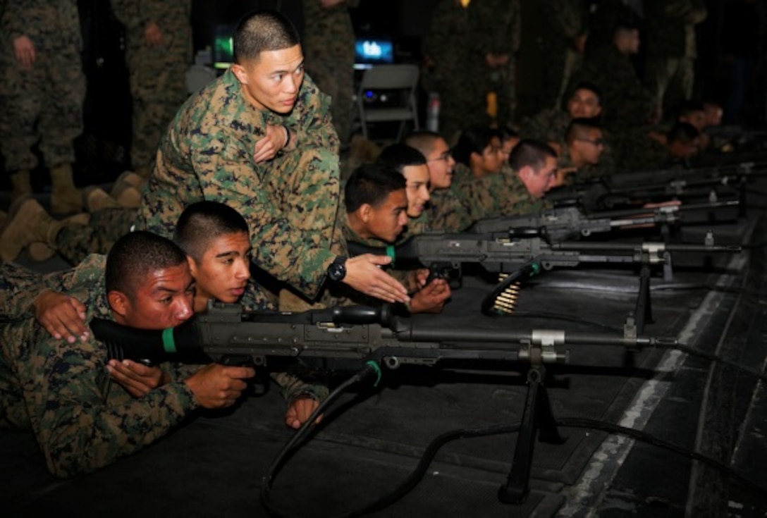 Sgt. Derick Organo, machine gunner, 3rd Battalion, 4th Marine Regiment, 1st Marine Division, explains the firing procedures for the M240B machine gun to Marine Corps Junior Reserve Officers' Training Corps cadets from Desert Hot Springs High School, at the Indoor Simulated Marksmanship Trainer Dec. 18, 2013. After firing, the cadets ate at the Phelps Mess Hall and were then taken to the Combat Center Marine Corps exchange, furthering their opportunity to experience how Marines live on a daily basis.
