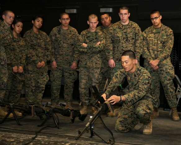 Sgt. Derick Organo, machine gunner, 3rd Battalion, 4th Marine Regiment, 1st Marine Division, explains the firing procedures for the M240B machine gun to Marine Corps Junior Reserve Officers' Training Corps cadets from Desert Hot Springs High School, at the Indoor Simulated Marksmanship Trainer Dec. 18, 2013. During their visit to the Combat Center, the cadets were given a period of instruction on different weapon systems and then given the opportunity to practice marksmanship skills at the ISMT.


