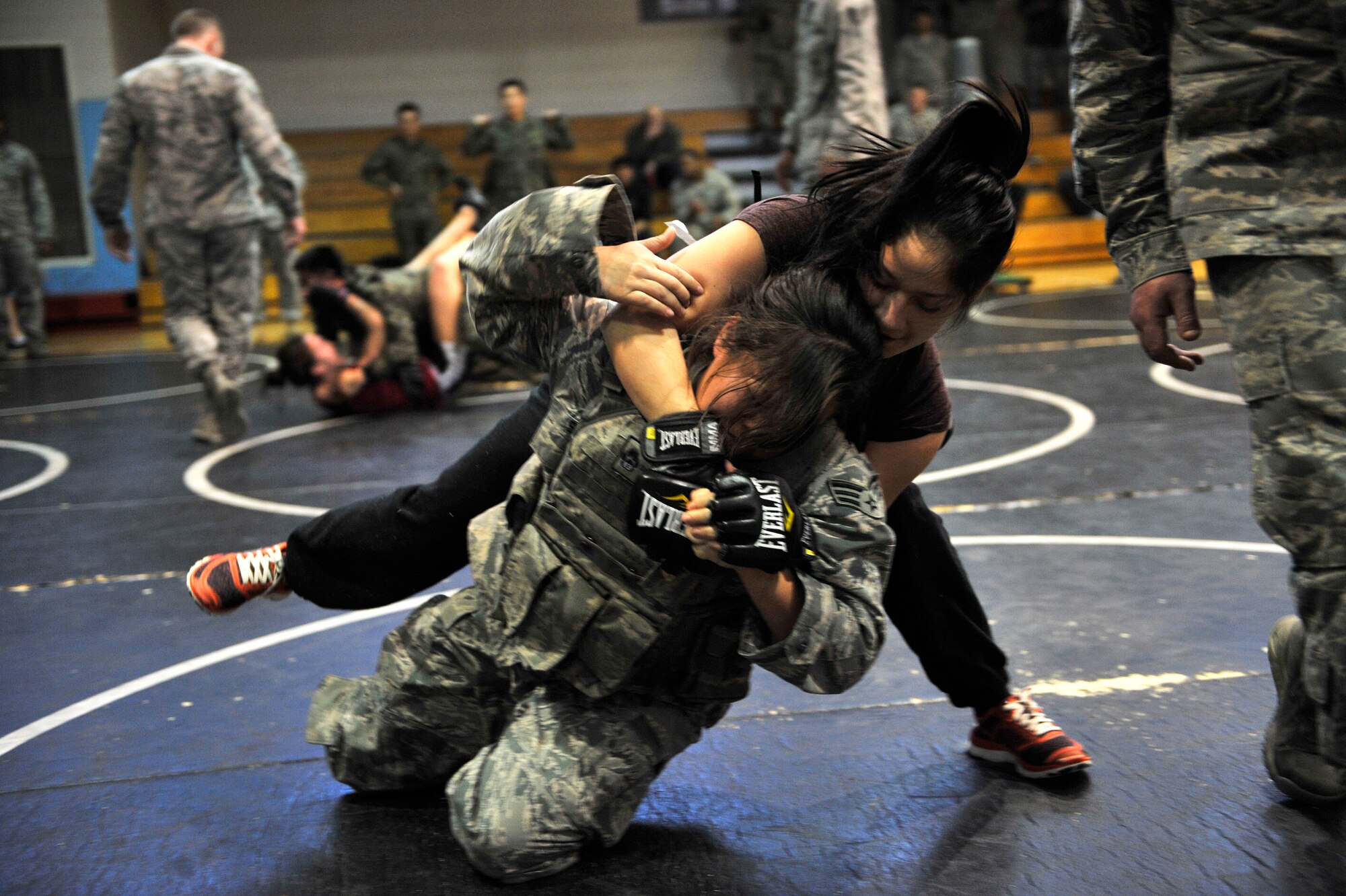 Senior Airman Kathy Shih, 51st Security Forces Squadron area supervisor, wrestles with another 51st SFS member during a Combat Readiness Course at Osan Air Base, Republic of Korea, Dec. 19, 2013. The combatives training allowed 51st SFS members to showcase all of the non-lethal tools and techniques in their arsenal. (U.S. Air Force photo/Staff Sgt. Emerson Nuñez)