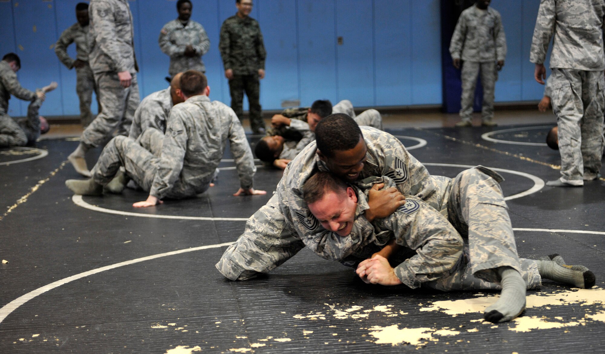 Master Sgt. Scott Larson, right, and Tech. Sgt. Anthony Johnson, 51st Security Forces Squadron area supervisors, grapple prior to a Combat Readiness Course at Osan Air Base, Republic of Korea, Dec. 19, 2013. All defenders are required to complete the combatives training upon arrival to the base. (U.S. Air Force photo/Staff Sgt. Emerson Nuñez)