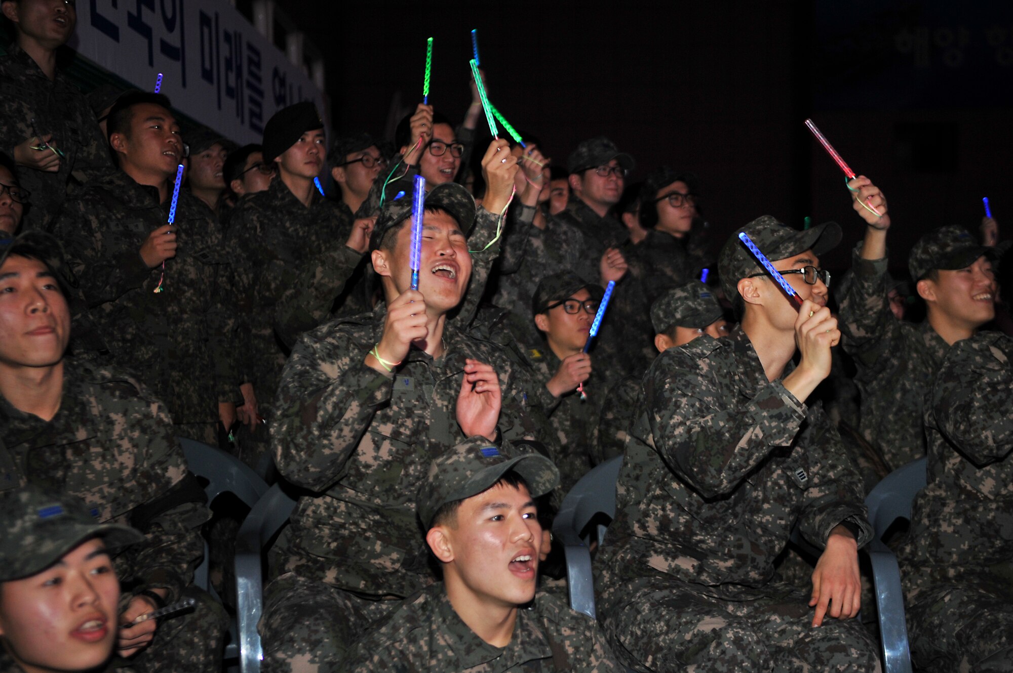Republic of Korea airmen and soldiers express their excitement during K-pop performances at the 60th Anniversary of the Republic of Korea and U.S. alliance concert at the Ichung Sports Cultural Center in Pyeongtaek-si, ROK, Dec. 18, 2013. Hundreds of U.S. and ROK military personnel and their families enjoyed a night of martial arts demonstrations and musical performances to celebrate the friendship and continued partnership between the two nations. (U.S. Air Force photo/Airman 1st Class Ashley J. Thum)