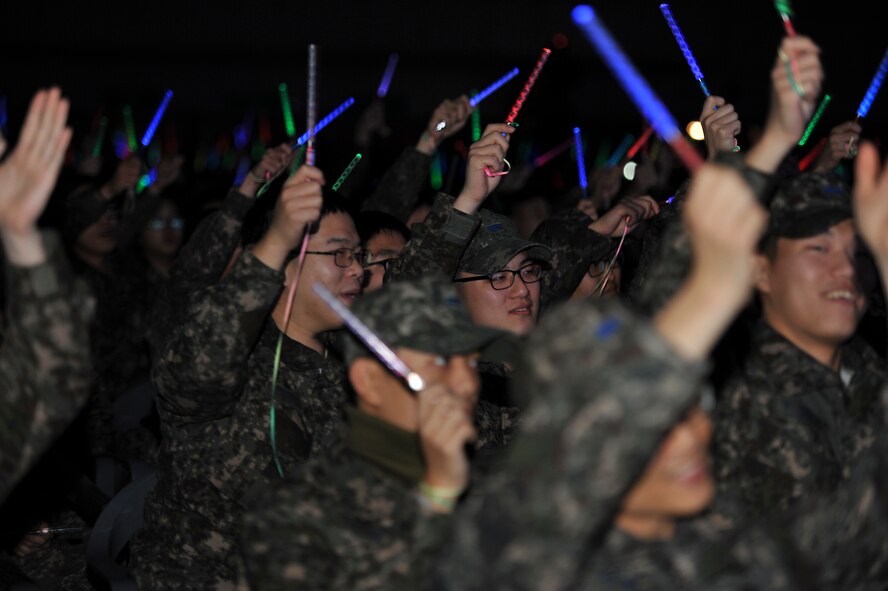 Republic of Korea airmen and soldiers wave glow sticks during the 60th Anniversary of the Republic of Korea and U.S. alliance concert at the Ichung Sports Cultural Center in Pyeongtaek-si, ROK, Dec. 18, 2013. The night’s festivities included performances by several K-pop groups and a tae kwon do demonstration. (U.S. Air Force photo/Airman 1st Class Ashley J. Thum)
