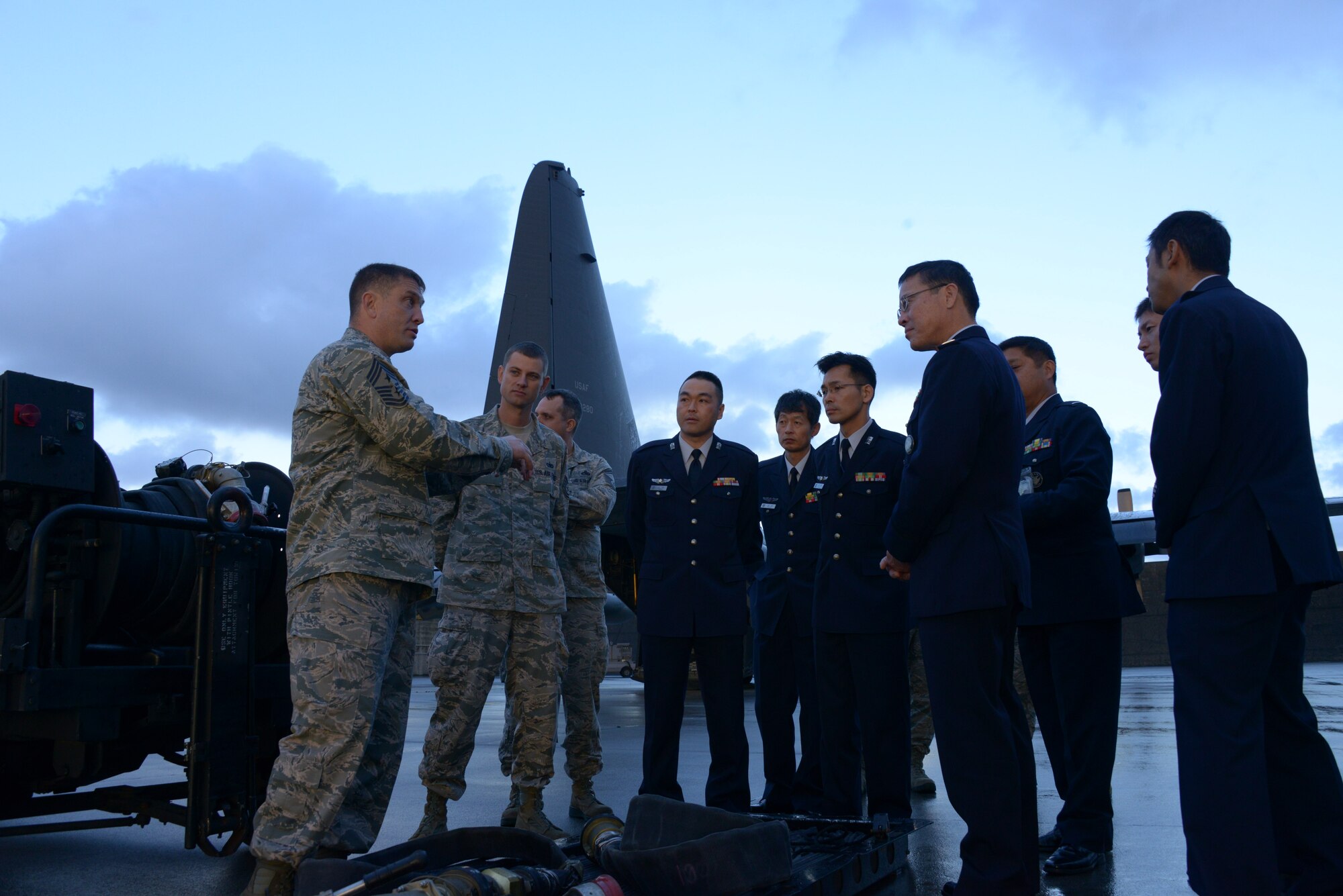 Chief Master Sgt. Joseph Montgomery, 353rd Special Operations Group command chief master sergeant, briefs Warrant Officer Takeshi Arai, senior enlisted advisor of the Japan Air Self Defense Force, along with other members from JASDF about the 353rd SOG capabilities during a visit Dec. 19, 2013, to Kadena Air Base, Japan. During the visit, Arai viewed an MC-130H Combat Talon II static display and spoke with the 353rd SOG top three.  (U.S. Air Force photo by Tech. Sgt. Kristine Dreyer)