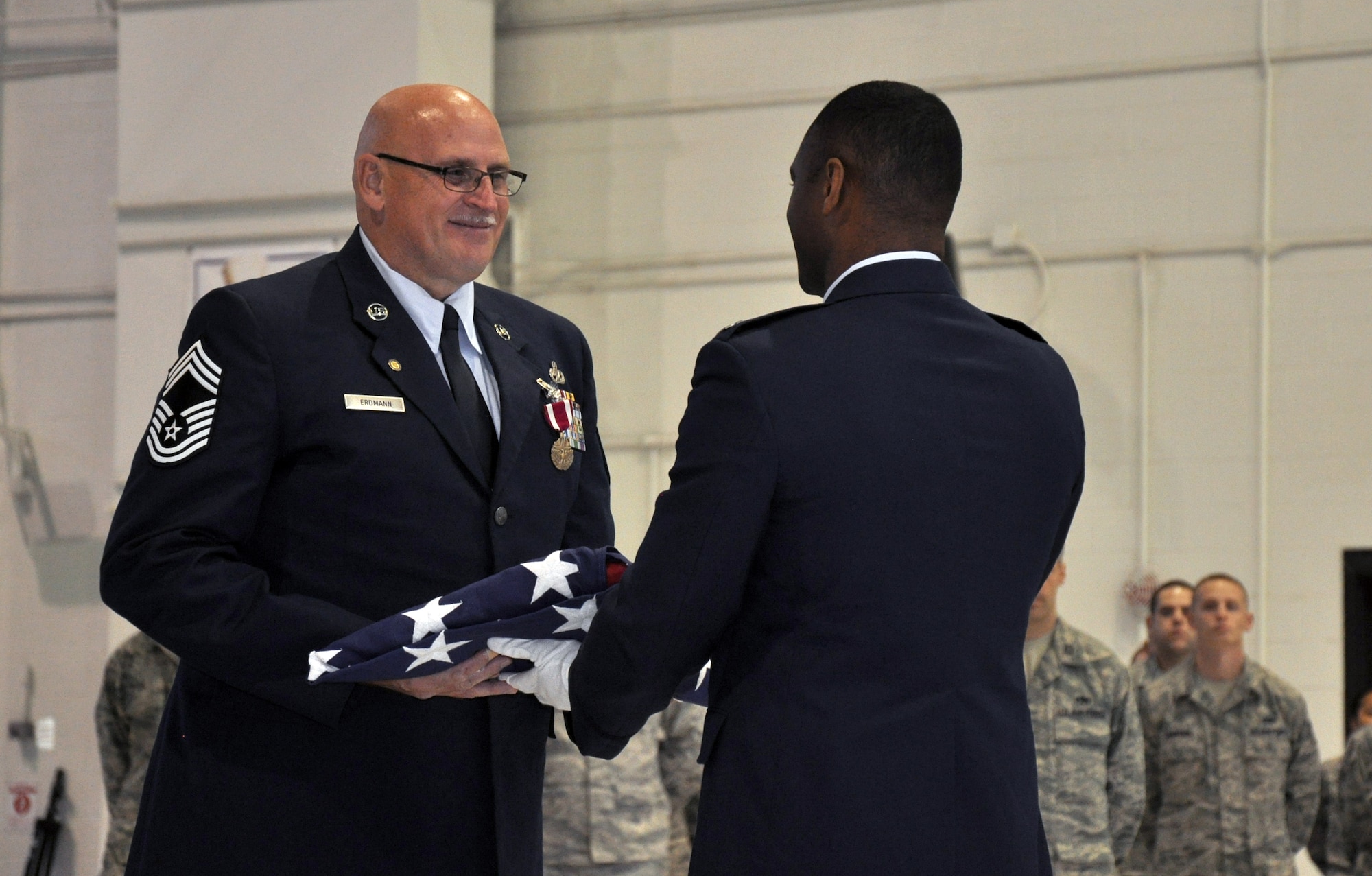Chief Master Sgt. Timothy Erdmann, 916th Maintenance Squadron superintendent accepts the American flag during his retirement ceremony, December 2013. (USAF photo by SSgt. Alan Abernethy, 916ARW/PA) 