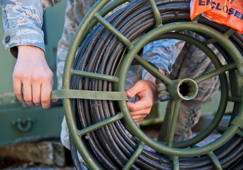 Senior Airman Brandon Seyl, 1st Special Operations Communications Squadron radio frequency transmissions systems journeyman, secures a strap to fasten cables in place at Hurlburt Field, Fla., Dec. 12, 2013. The tactical communications flight maintains equipment so it’s ready to deploy at a moment’s notice. (U.S. Air Force photo/Senior Airman Michelle Vickers)  