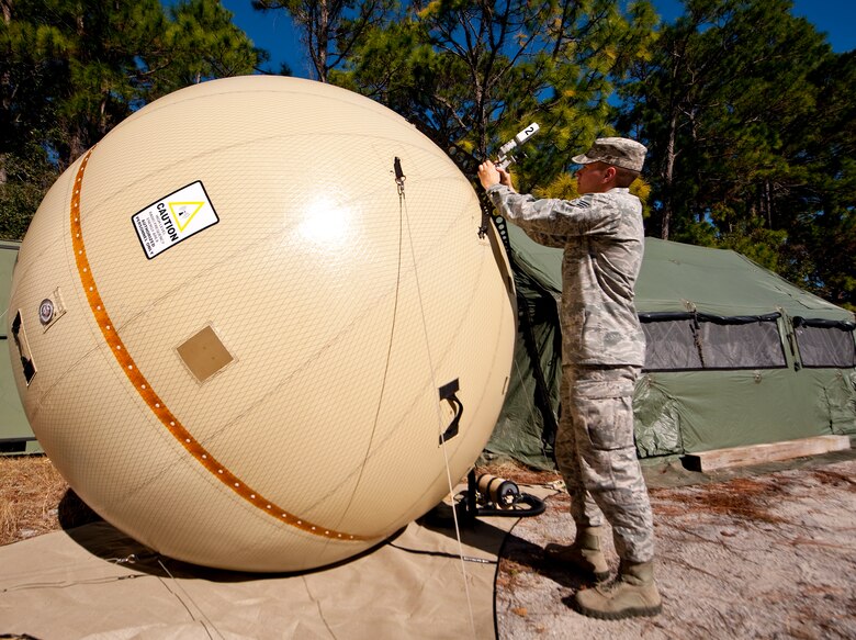 Senior Airman Brandon Seyl, 1st Special Operations Communications Squadron radio frequency transmissions systems journeyman, sets up a satellite system at Hurlburt Field, Fla., Dec. 12, 2013. The system will be pointed at a satellite in order to provide secured and unsecured telephone lines. (U.S. Air Force photo/Senior Airman Michelle Vickers) 