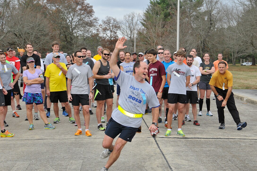 AEDC Space and Missile Director Lt. Col. Jay Orson warms-up the runners displaying turkey feathers on his belt during the AEDC Turkey Trot 5k run and 1.5 mile walk. (Photo by Rick Goodfriend)