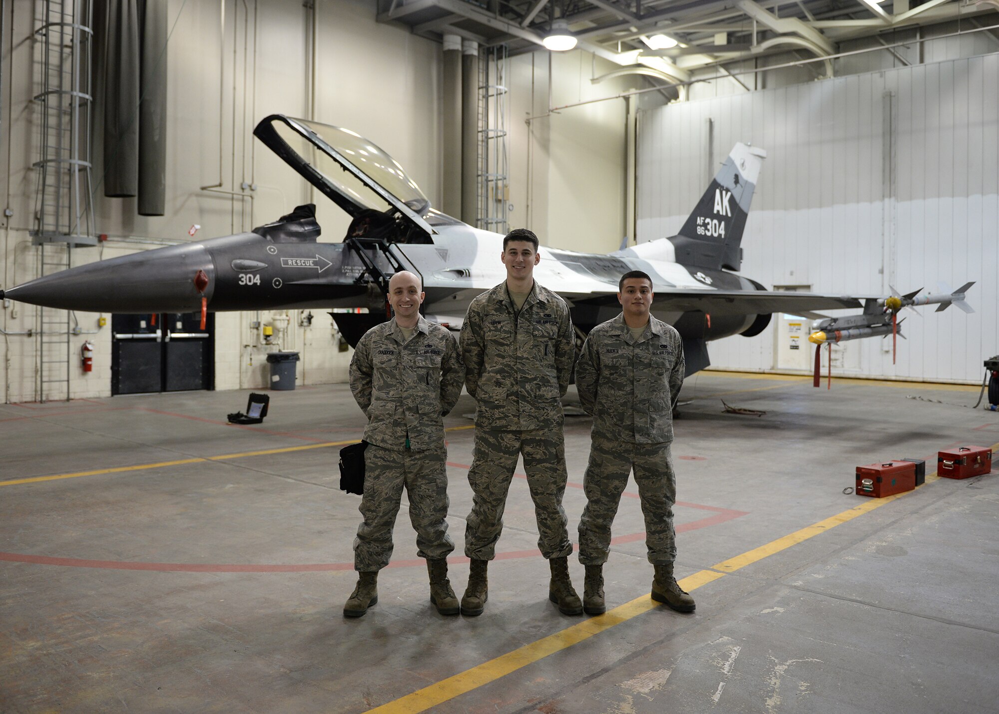 U.S. Air Force Staff Sgt. Joe Craddock, Senior Airman Joseph Levin and Airman 1st Class Uziel Huerta, 354th Aircraft Maintenance Squadron weapons load crew members pose for a group photo during an annual load crew competition Dec. 13, 2013, Eielson Air Force Base, Alaska. The Competition Highlighted Eielson's top laod crews in recognition for their outstanding performance and safety record throughout the year. (U.S. Air Force photo by Senior Airman Shawn Nickel/Released)