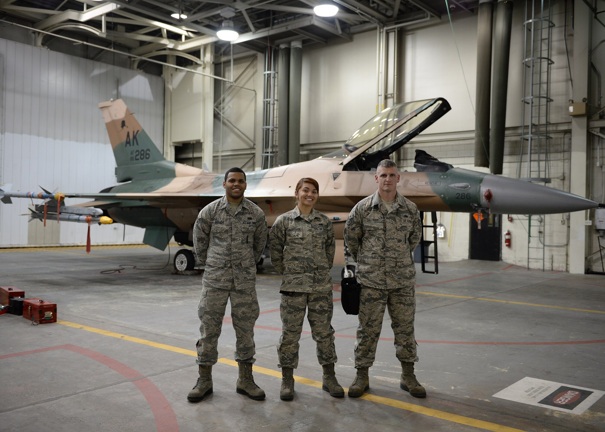U.S. Air Force Senior Airman Ralphy Rosado, Senior Airman Alexa Donithan and Staff Sgt. Brett Dallinger, 354th Aircraft Maintenance Squadron weapons load crew members pose for a group photo during an annual load crew competition Dec. 13, 2013, Eielson Air Force Base, Alaska. The Competition Highlighted Eielson's top laod crews in recognition for their outstanding performance and safety record throughout the year. (U.S. Air Force photo by Senior Airman Shawn Nickel/Released)