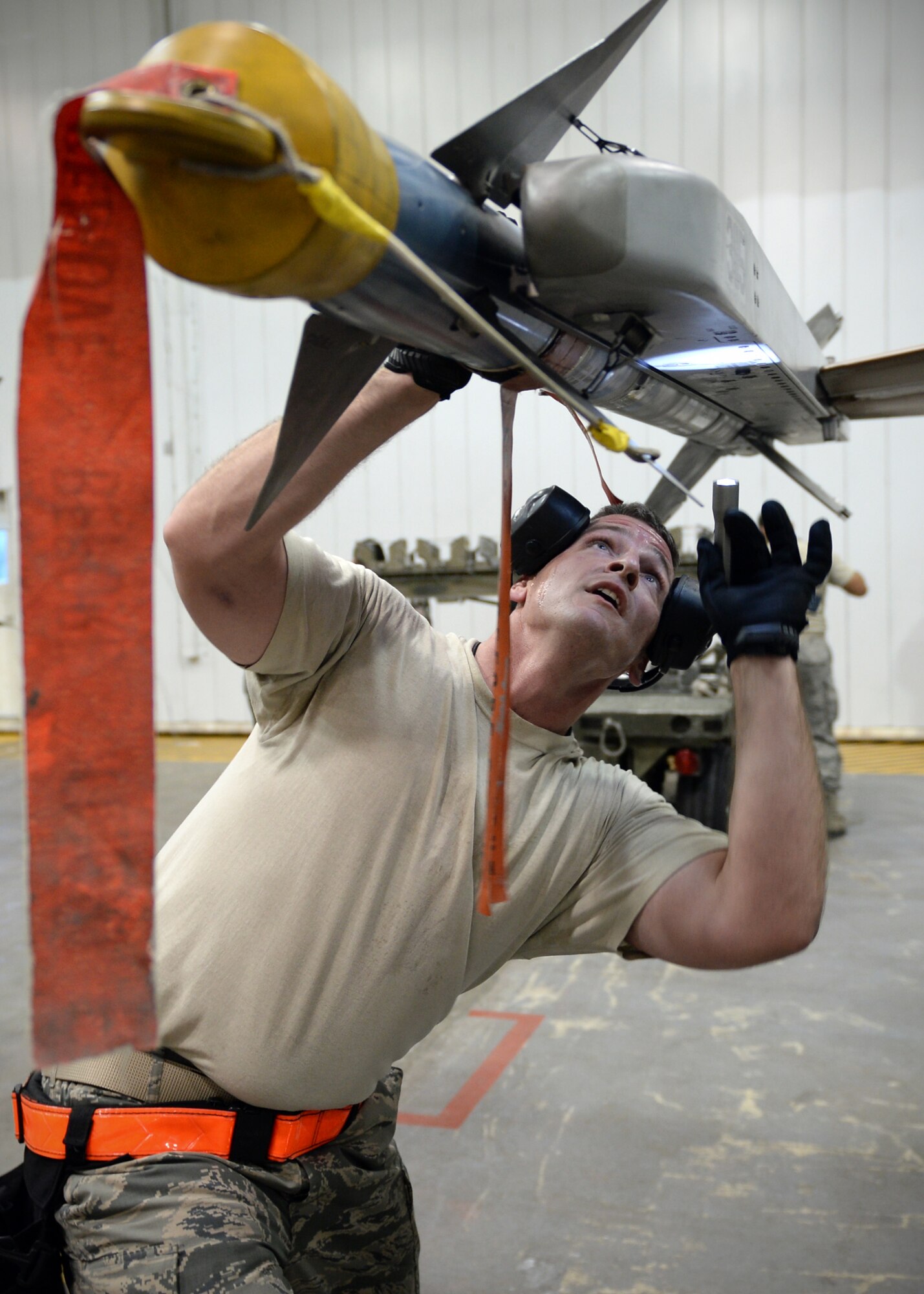 U.S. Air Force Staff Sgt. Brett Dallinger, 354th Aircraft Maintenance Squadron weapons load crew member, secures an AIM-9 Sidewinder Missile to an F-16 Fighting Falcon in an aircraft maintenance hangar during an annual load crew competition Dec. 13, 2013, Eielson Air Force Base, Alaska. Dallinger led his team, Crew 4, in a competition that highlighted Eielson's top performing load crews. (U.S. Air Force photo by Senior Airman Shawn Nickel/Released)