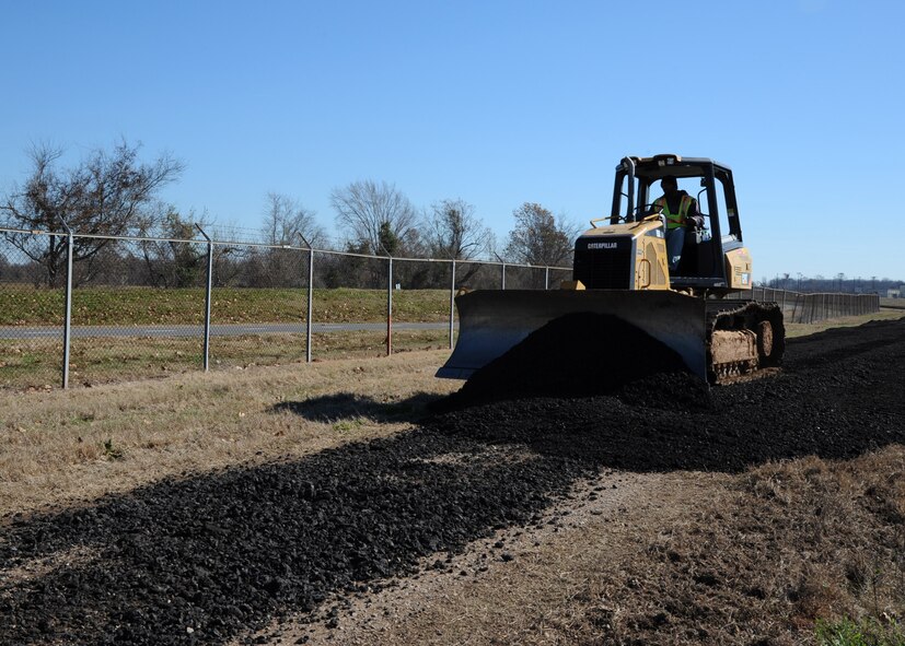 A Caterpillar Crawler Tractor pushes asphalt to make a road on Barksdale Air Force Base, La., Dec. 18, 2013. The road is being made from scrap asphalt removed from the runway to help security forces members travel more efficiently around the flightline. (U.S. Air Force photo/Senior Airman Joseph A. Pagán Jr.)
