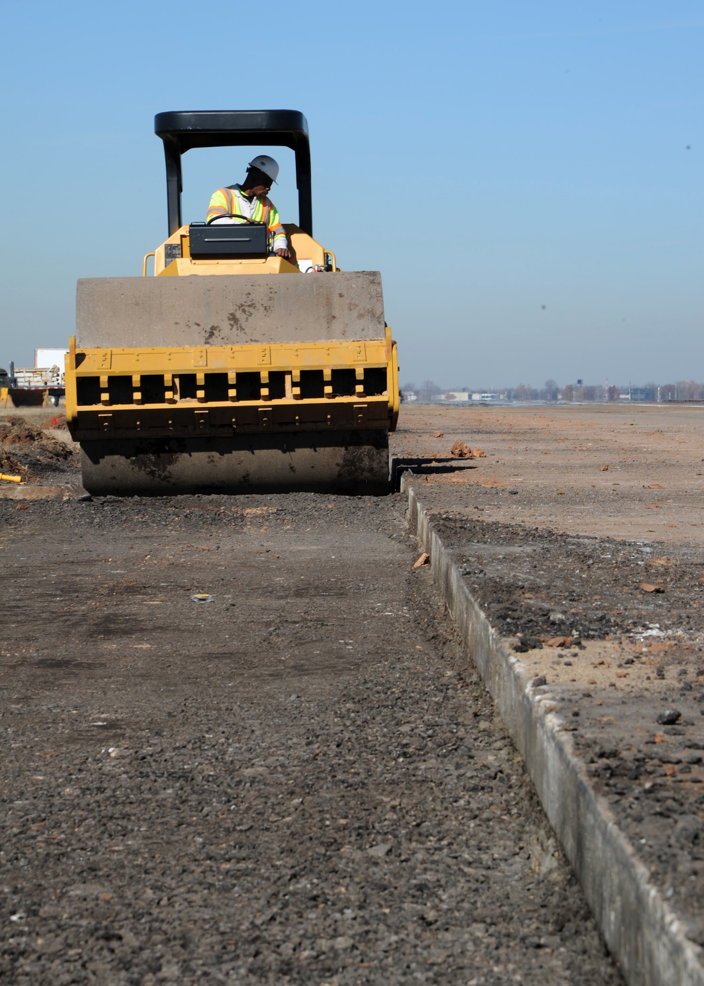 A Caterpillar Asphalt Roller compacts rock on the runway at Barksdale Air Force Base, La., Dec. 18, 2013. A contractor used the roller to compact the rock to allow for an even pour of concrete. (U.S. Air Force photo/Senior Airman Joseph A. Pagán Jr.)