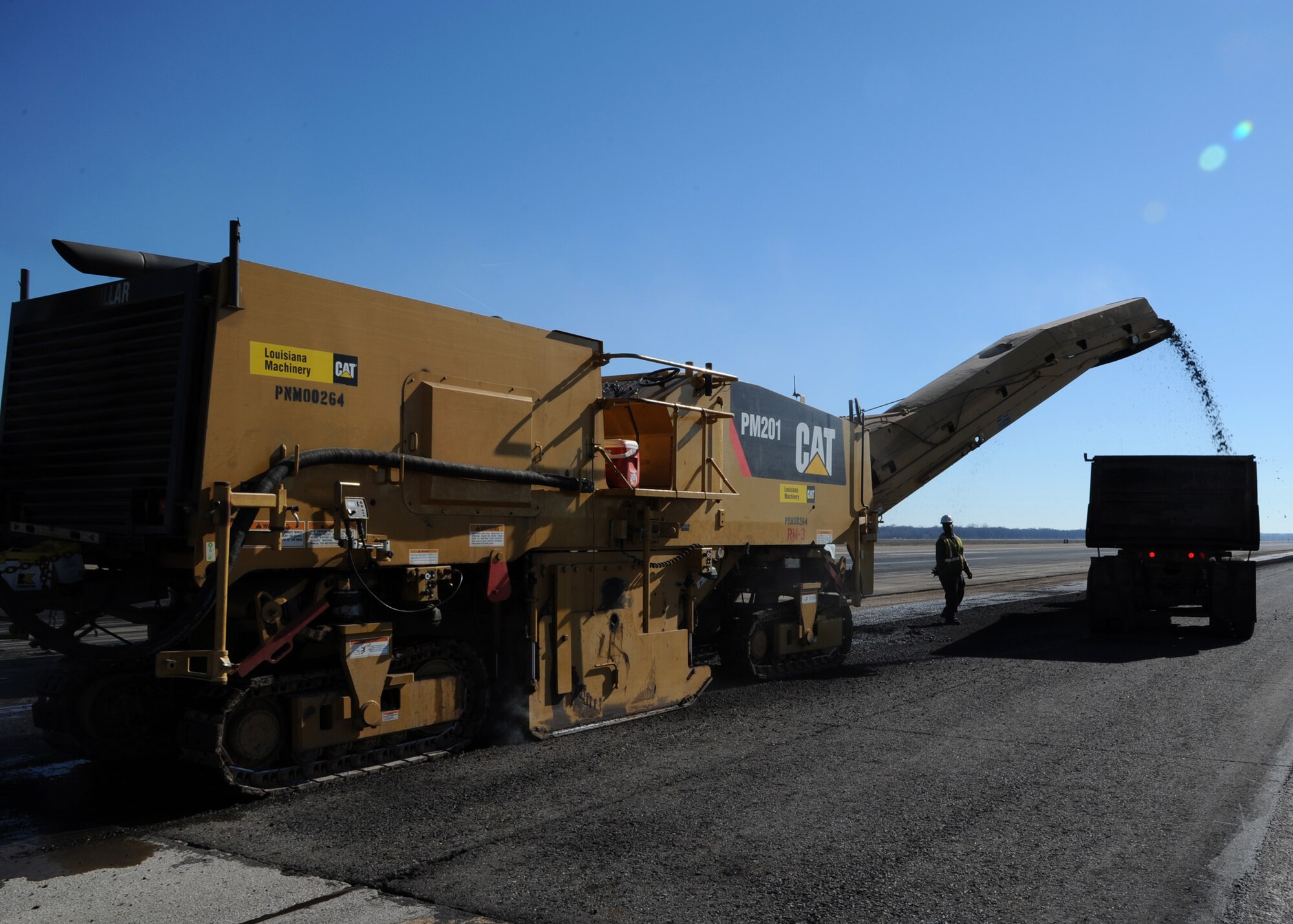 A Caterpillar PM-201 Cold Planer removes asphalt on the runway at Barksdale Air Force Base, La., Dec. 18, 2013. Contractors are milling and replacing the inner asphalt overlay on the runway to repair the foreign object debris that has built up over the years of operation. (U.S. Air Force photo/Senior Airman Joseph A. Pagán Jr.)