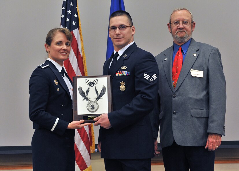 Senior Airman Travis Quimby, 341st Security Forces Squadron, center, receives the Academic Achievement Award at the Airman Leadership School Class 14-B graduation banquet.  Shown presenting the award are Col. Marné Deranger, 341st Missile Wing vice commander, and Denis Miller, representative for the Malmstrom Retiree Association.  The Academic Achievement Award denotes excellence as a scholar and is presented to the student with the highest academic standing, excluding the John L. Levitow Award recipient.  The graduation banquet was held Dec. 17 at the Grizzly Bend.  (U.S. Air Force photo / John Turner)