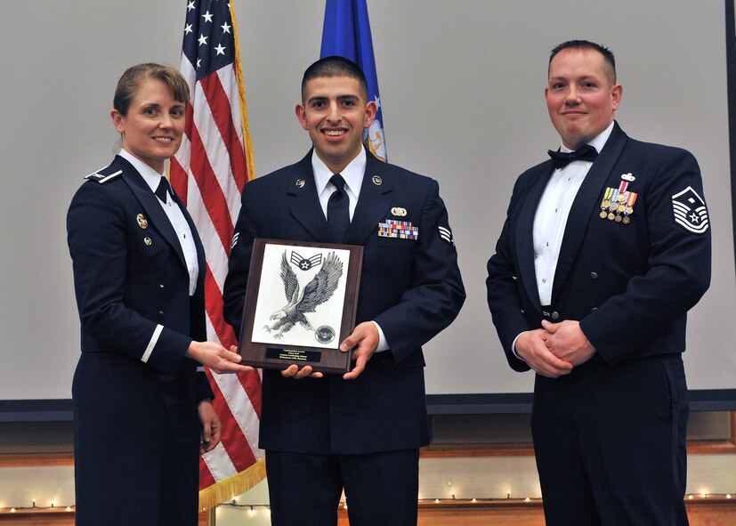 Senior Airman Daniel Hernandez, 819th RED HORSE Squadron, center, receives the Commandant Award at the Airman Leadership School Class 14-B graduation banquet.  Shown presenting the award are Col. Marné Deranger, 341st Missile Wing vice commander, and Master Sgt. Colin Crandall, representative for Air Force Sergeants Association Chapter 1156.  The Commandant Award is sponsored by AFSA and is presented to the student who, in the commandant’s judgment, made the most significant contribution to the overall success of the class.  The graduation banquet was held Dec. 17 at the Grizzly Bend.  (U.S. Air Force photo / John Turner)
