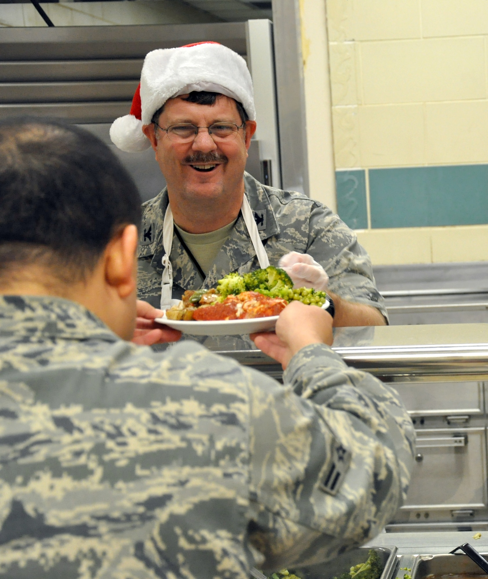 Col. Gregory Gilmour, 916th wing commander gets into the holiday spirit by serving lunch at the Southern Eagle dining facility during the December drill weekend. (USAF photo by Major Erin Karl, 916ARW/PA) 