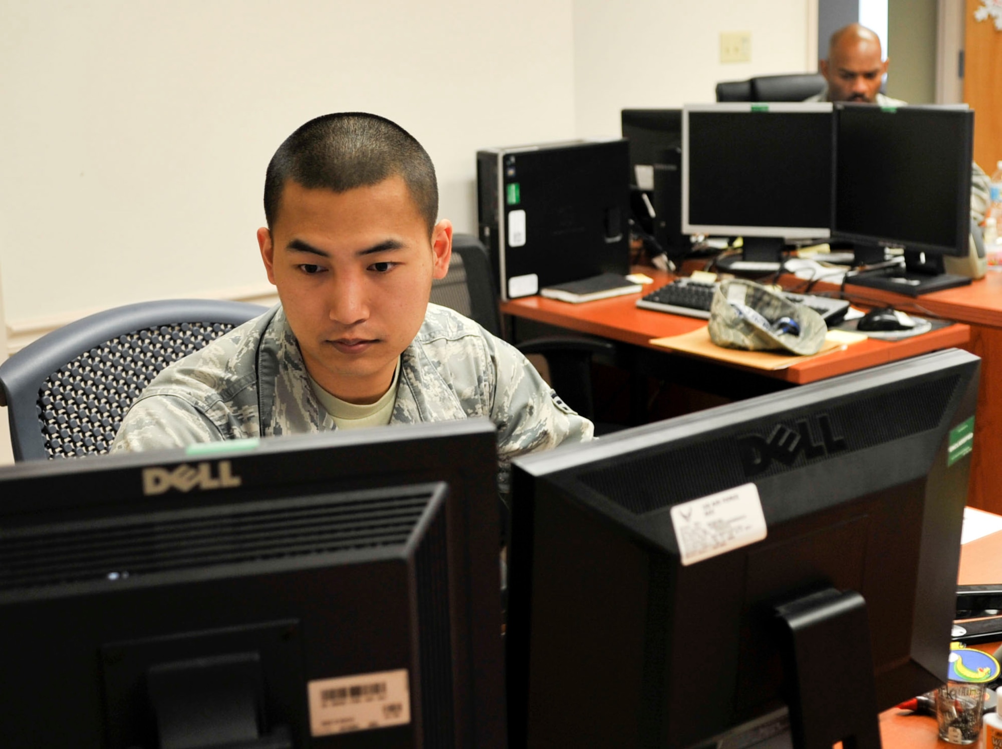 Senior Airman Youl Lang, 2nd Force Support Squadron Individual Personnel Readiness technician, reviews a member's record on Barksdale Air Force Base, La., Dec. 19, 2013. Lang is traveling to South Korea to see his family for the holidays courtesy of Operation Bright Holiday. (U.S. Air Force Photo by Airman 1st Class Benjamin Raughton)