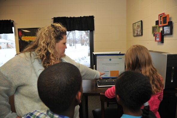 Maureen Haney, program manager of Tutor.com, shows children how to sign up for Tutor.com/Military Dec. 12, 2013, at the base Youth Center on Grand Forks Air Force Base, N.D. Haney briefed parents, educators and students about the free online tutoring and homework assistance that is provided 24/7 to military families worldwide through the program. (U.S. Air Force photo/Senior Airman Xavier Navarro)