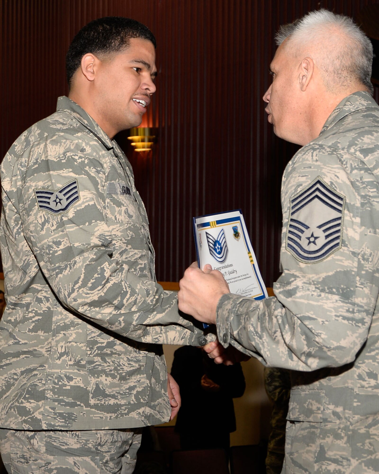 HANSCOM AIR FORCE BASE, Mass. -- Chief Master Sgt. Mitchell Balutski, Hanscom senior enlisted advisor, congratulates Staff Sgt. Jeremy Guidry on his Stripes for Exceptional Performers, or STEP promotion, to technical sergeant at a town hall meeting in the Base Theater Dec 19. Commanders are given opportunities to promote outstanding individuals to staff sergeant, technical sergeant or master sergeant through the STEP promotion process. (U.S. Air Force photo by Mark Herlihy)