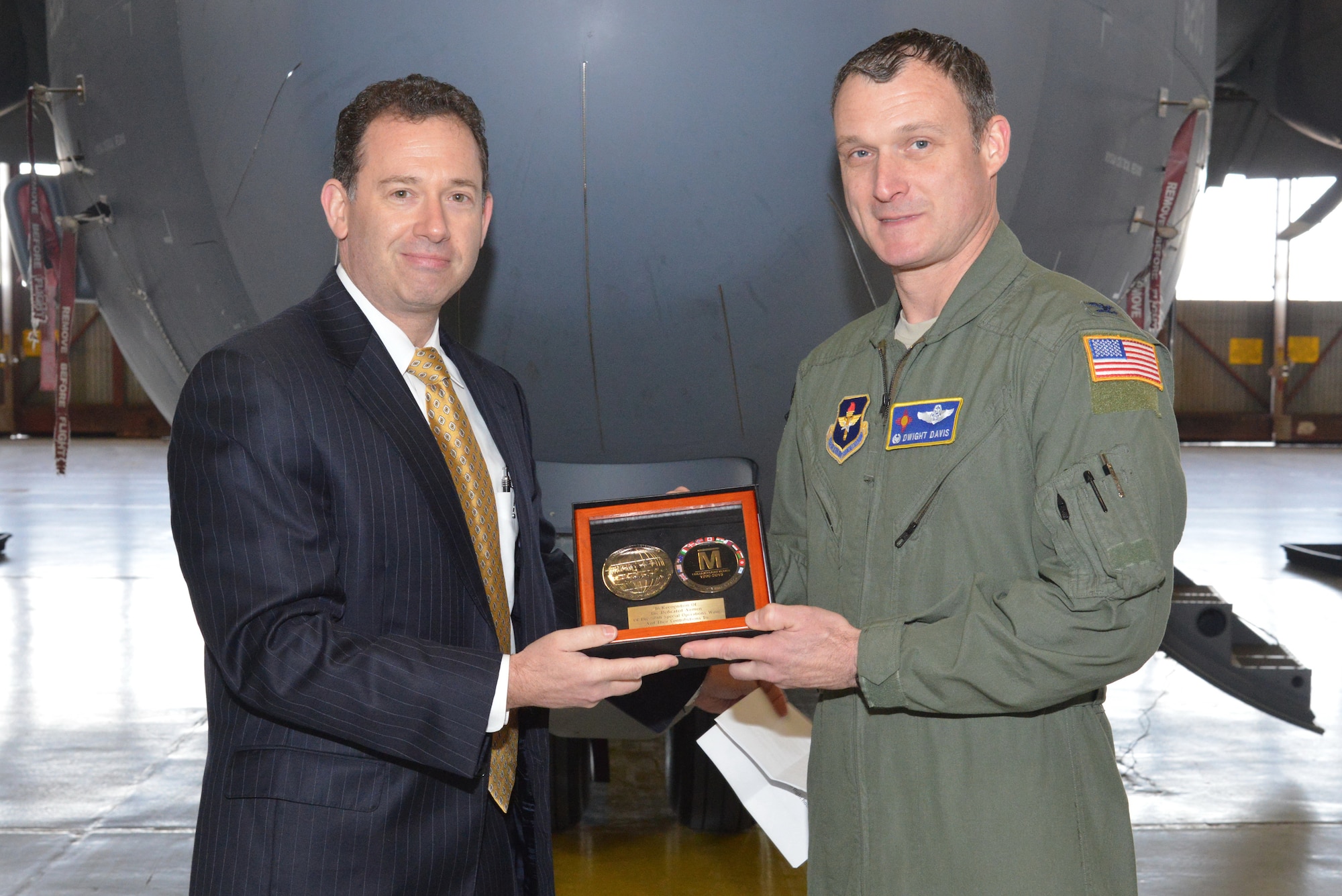 Lockheed Martin's Peter London, left, presents a plaque to Col. Dwight Davis, 58th Operations Group commander, at a ceremony Dec. 18 commemorating a million C-130J flight hours. (Photo by Ken Moore)