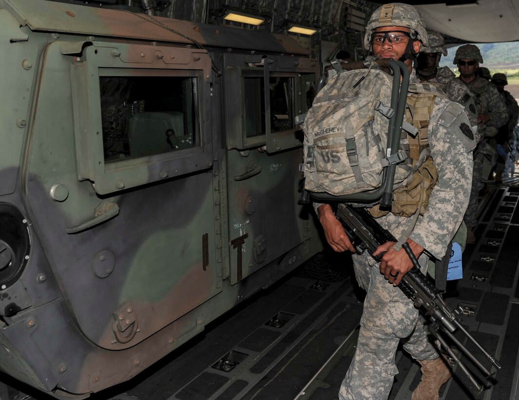 Soldiers from the 25th Infantry Division load a C-17 Globemaster III from the 535th Airlift Squadron during a validation exercise at Wheeler Army Airfield, Hawaii, Dec. 16, 2013. During the VALEX, a Hickam-based C-17 picked up two HUMVEES and 35 passengers to test the unit’s ability to rapidly deploy to anywhere within the Pacific area of responsibility within 24 hours. (U.S. Air Force photo/Staff Sgt. Terri Paden)