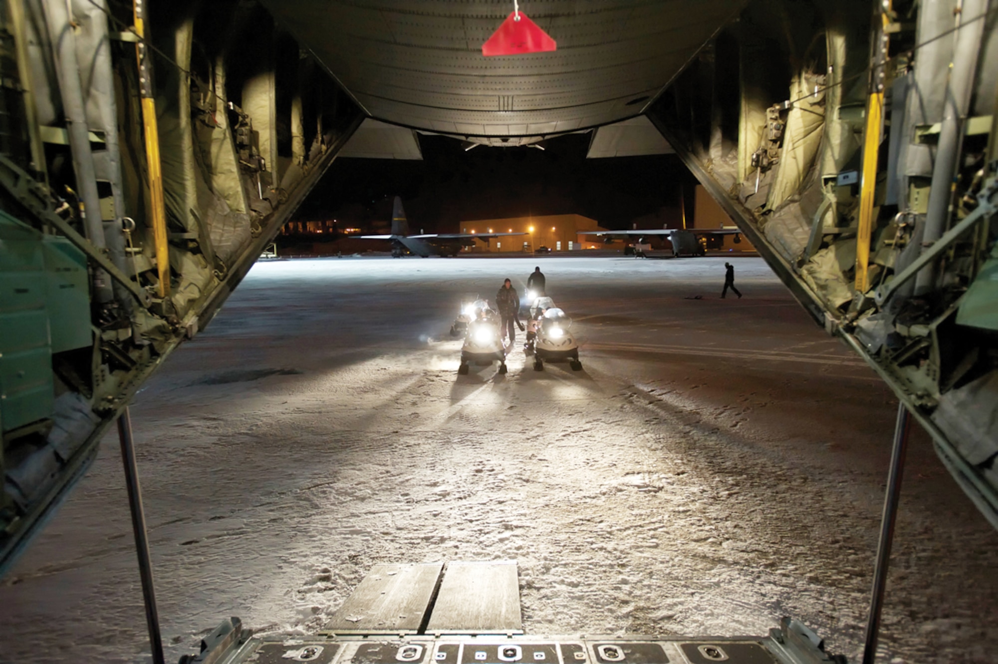Alaska Marines prepare to load snowmachines onto an Air Force C-130 Hercules at Joint Base Elmendorf-Richardson, Dec. 13. The Air Force will take the Marines, snowmachines and sleds to visit remote villages and give away more than 1,700 toys. (U.S. Air Force photo/Staff Sgt. Robert Barnett)