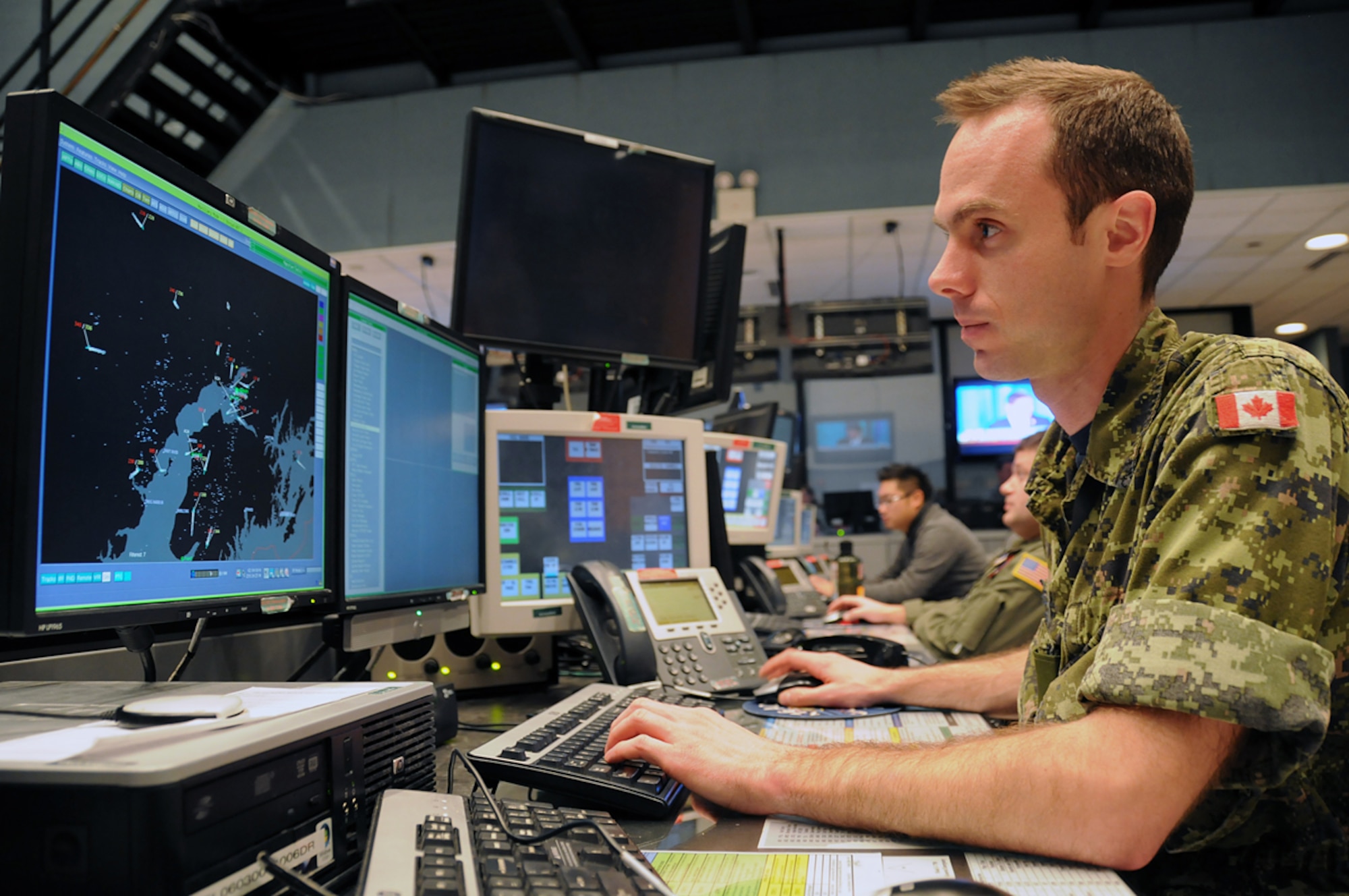 Royal Canadian Air Force Capt. Dave Gosselin, 176th Air Defense Squadron senior director, tracks aircraft in Alaska air space ensuring air sovereignty in the Alaskan NORAD Region Regional Air Operations Center. U.S. and Canadian servicemembers utilize 15  radar stations to monitor Santa as he traverses the airspace around the northern latitudes of North America, a mission ANR has successfully accomplished for 50 years. (U.S. Air Force photo/Tech. Sgt. John Gordinier)